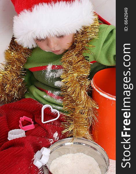 Toddler wearing a christmas hat, baking christmas cookies