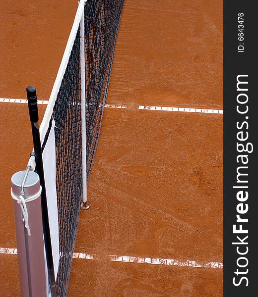 Tennis court top view on net with and orange surface with white lines. Tennis court top view on net with and orange surface with white lines.