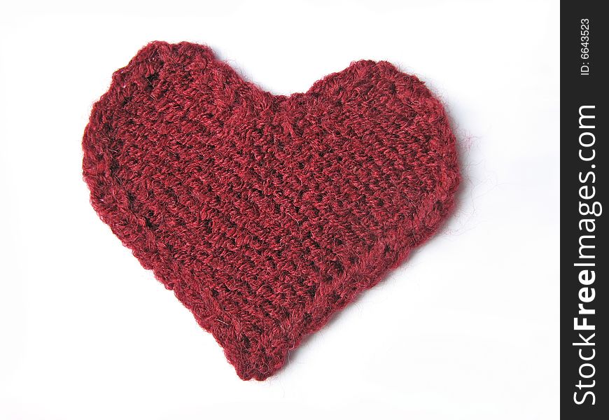 Cherry-coloured knitted heart on white background. Cherry-coloured knitted heart on white background
