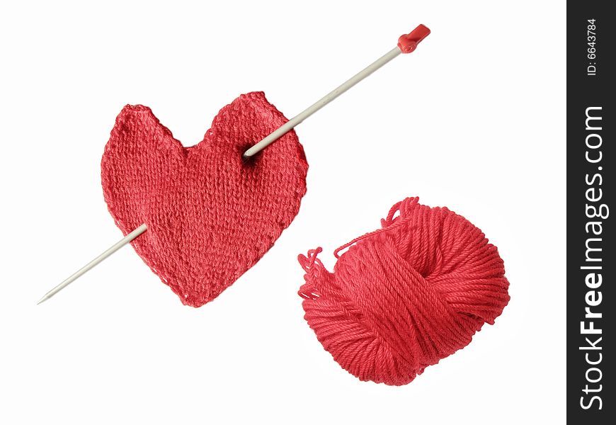 Red knitted heart with needle which looks like Eros' arrow and clew. Red knitted heart with needle which looks like Eros' arrow and clew