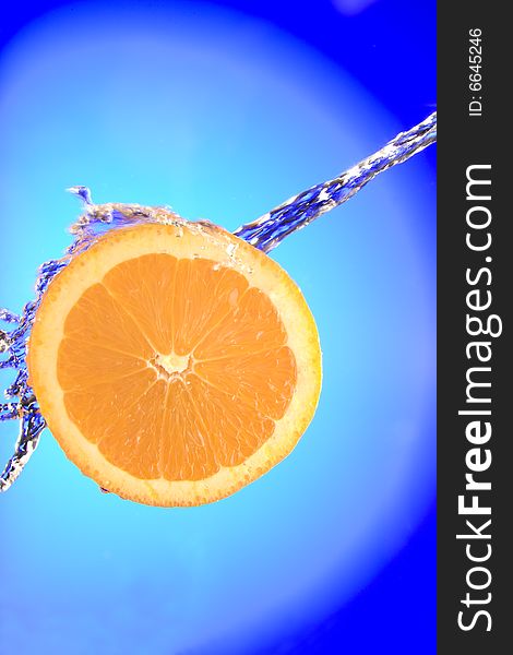 Close up view of sliced orange piece getting splashed with water. Close up view of sliced orange piece getting splashed with water