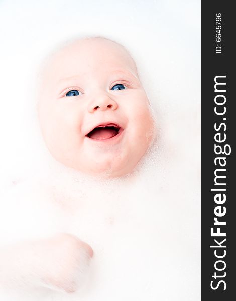 Closeup little smiling baby portrait in the bathroom. Closeup little smiling baby portrait in the bathroom