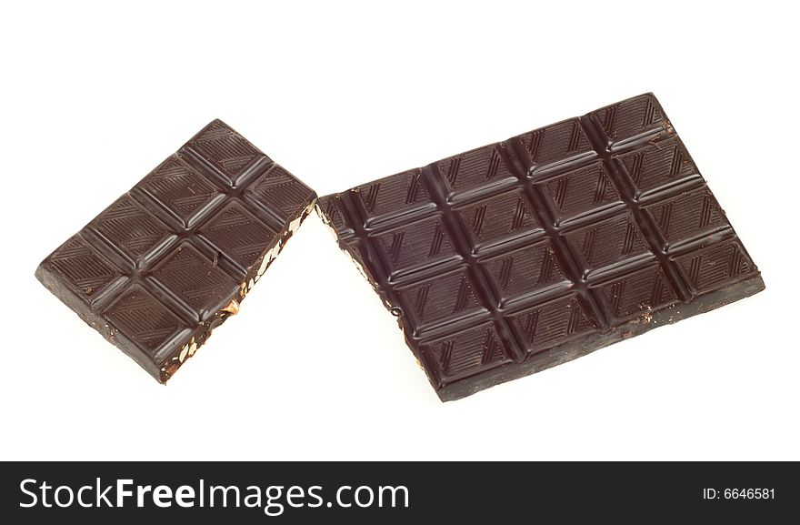 Two broken pieces of dark chocolate isolated on a white background