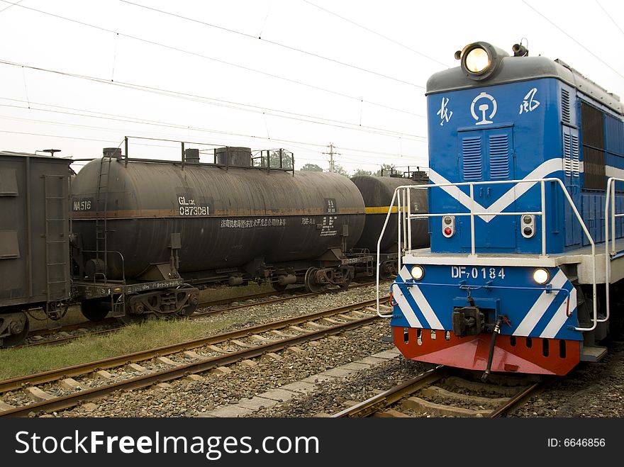 Blue locomotive and train on railway