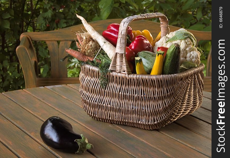 Aubergines and other vegetables in a wicker basket on the table. Aubergines and other vegetables in a wicker basket on the table.