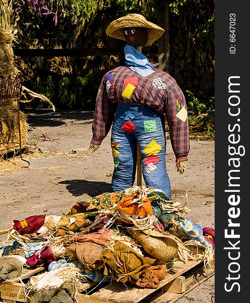 Black straw woman standing over a pile of straw dolls clothes. Black straw woman standing over a pile of straw dolls clothes