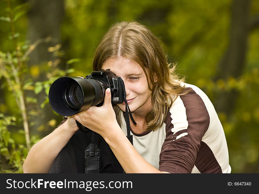 Young femal photographer in autumn forest