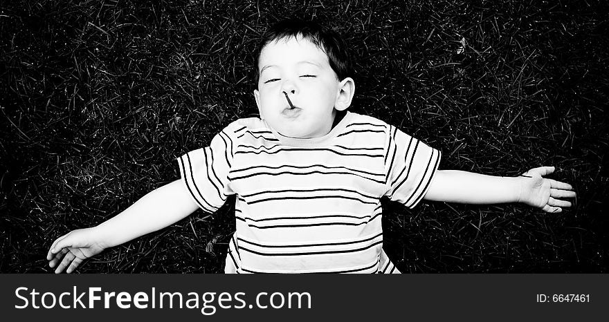 Black and white picture of a kid sleeping in the grass