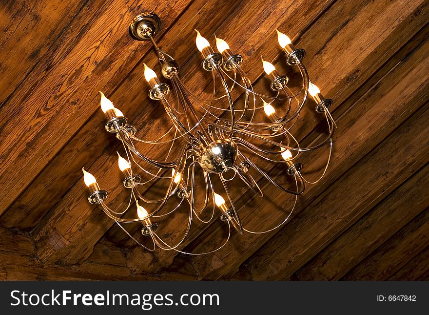 Photo of chandelier on the wooden 	ceiling