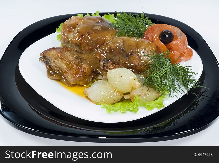 Chicken legs in sauce with stewed onions and tomatoes, isolated on white