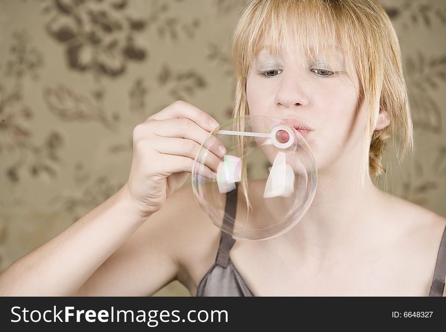 Pretty young girl with blue eyes blowing a bubble. Pretty young girl with blue eyes blowing a bubble