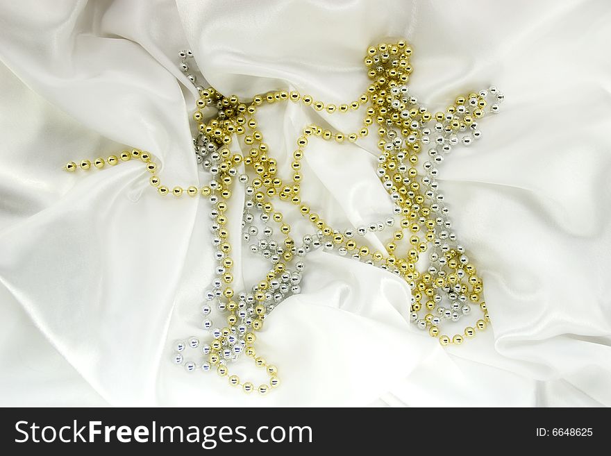 Gold and silver beads on white silk