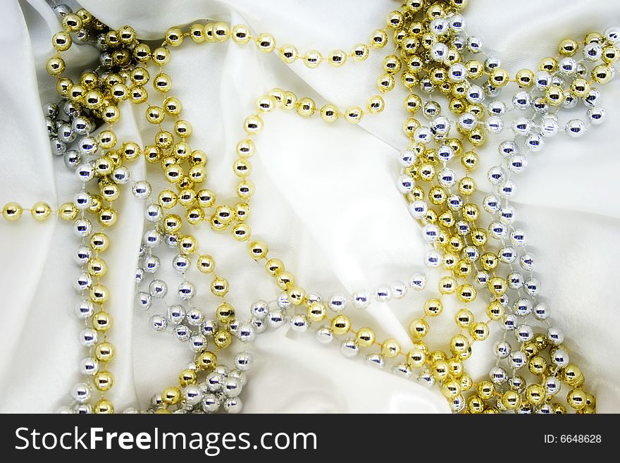 Gold and silver beads on white silk