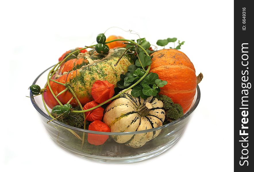 Isolated pumpkins composition in glass vase. Isolated pumpkins composition in glass vase