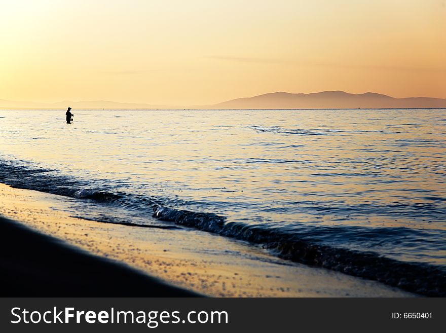 Fisherman silhouette at sunrise, Tuscany, Italy