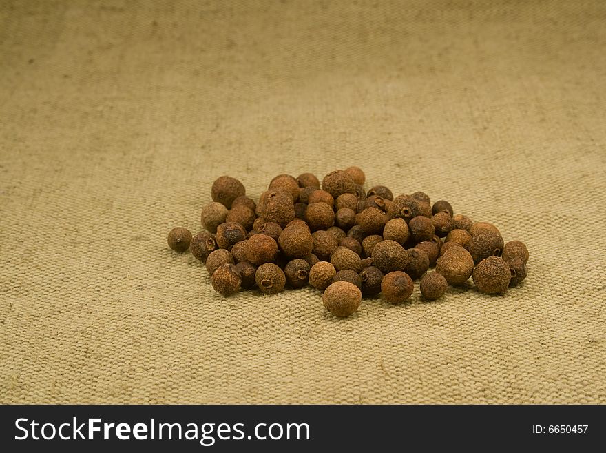 Whole dried allspice fruits on burlap