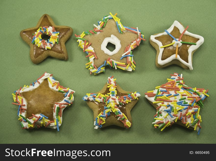 Two rows of Christmas cookies with border of green paper around them. Two rows of Christmas cookies with border of green paper around them