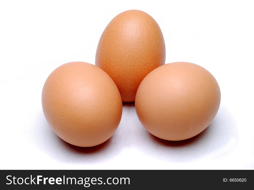 Three free range eggs on a white linen background. Three free range eggs on a white linen background.