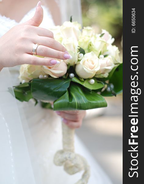 Hands of bride holding wedding bouquet with roses. Hands of bride holding wedding bouquet with roses