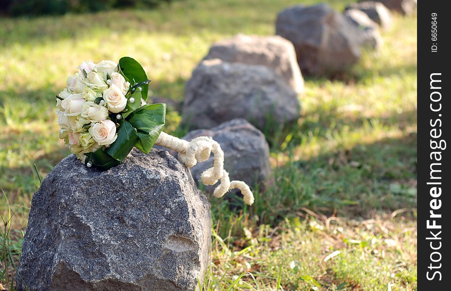 The wedding bouquet with white roses on a stone. The wedding bouquet with white roses on a stone