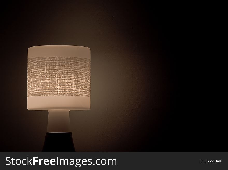 A bedside lamp  glowing in the dark