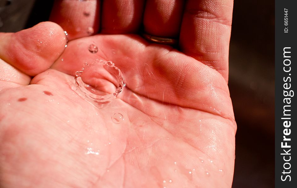 A water drop is caught in the hand. Clean drinking water is a precious resource. A water drop is caught in the hand. Clean drinking water is a precious resource.