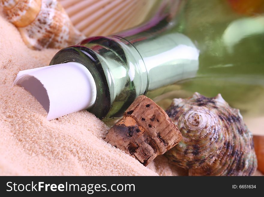 Bottle with a message in it on sand with seashells. Bottle with a message in it on sand with seashells