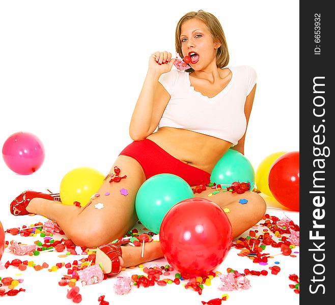 Young caucasian eating candy and surrounded by bunch of candies and balloons. Young caucasian eating candy and surrounded by bunch of candies and balloons