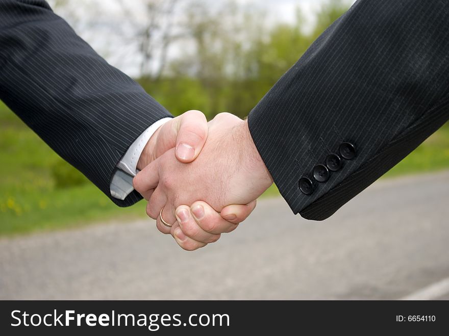 Two young businessmen shaking hands