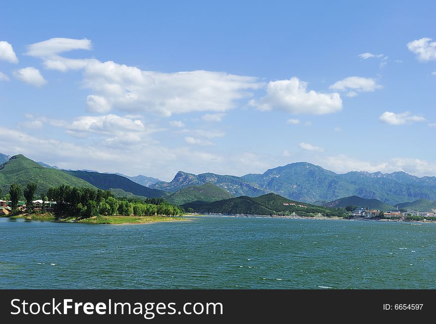 View of lake and mountains, blue sky and white clouds
