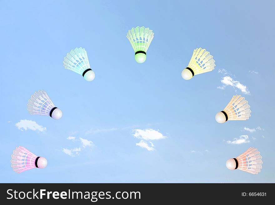 Flying shuttlecocks in the form of a rainbow in the blue sky