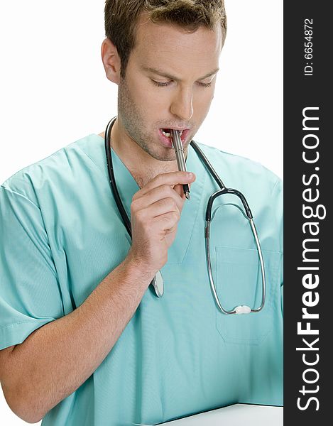 Doctor putting pen in his mouth and looking in writing pad