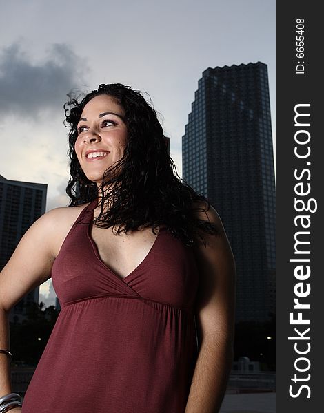 Young female posing with tall office buildings in the background. Young female posing with tall office buildings in the background.