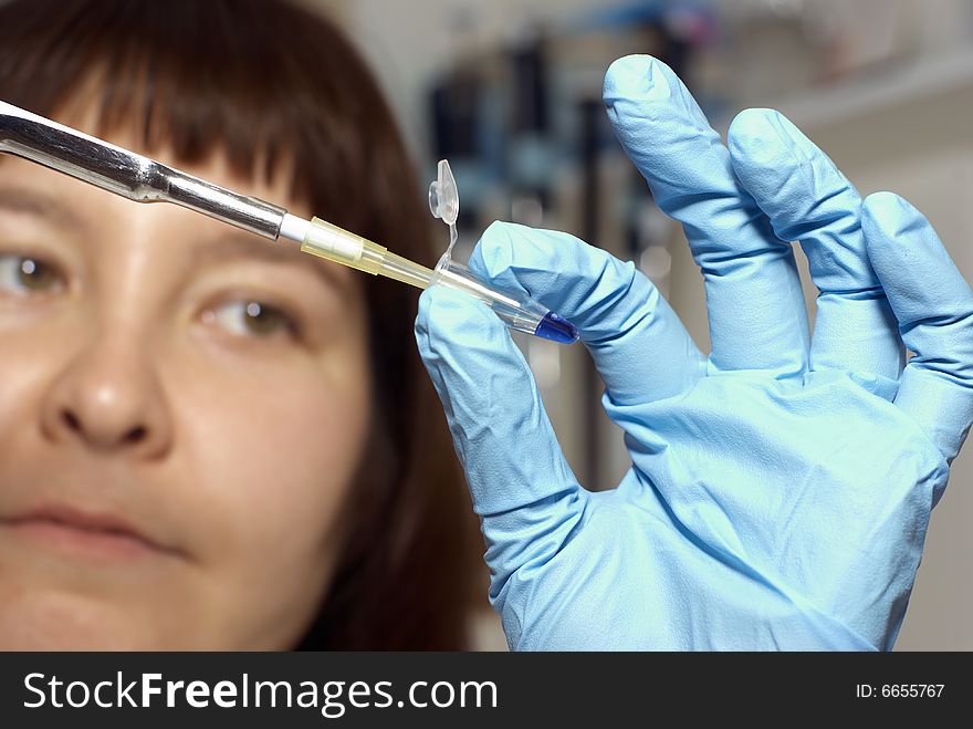 Female researcher in gloves with dropper