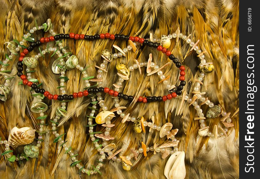 Necklace, cheap finery and feather close-up. Necklace, cheap finery and feather close-up
