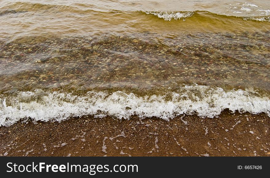 The wave runs on sandy coast. The wave runs on sandy coast