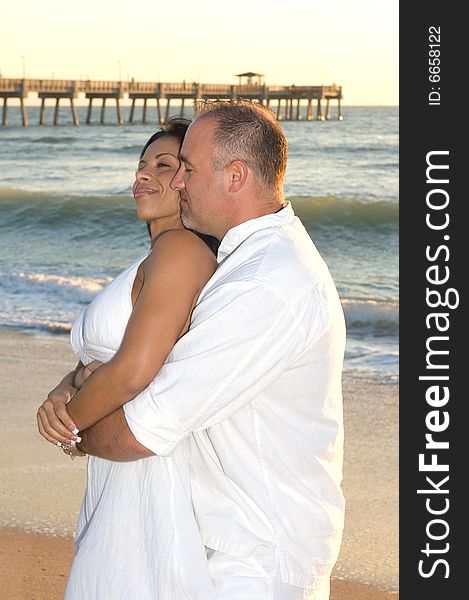 Man Holding Woman at the beach at sunrise. Man Holding Woman at the beach at sunrise