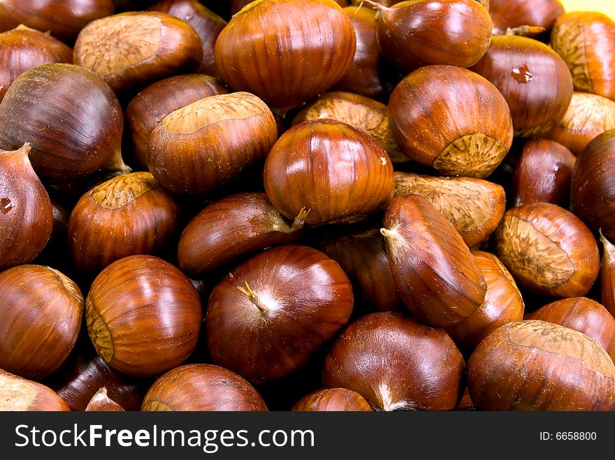 Many Ripe Chestnuts On Yellow Background