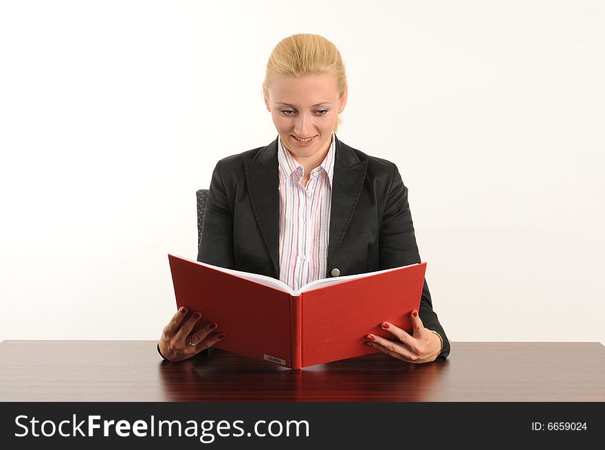 Young woman at the office, holding a red book in her hands. Young woman at the office, holding a red book in her hands.