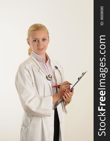 Female medical doctor working with her clipboard. Using a Stethoscope. Female medical doctor working with her clipboard. Using a Stethoscope.