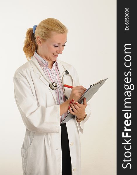 Female medical doctor working with her clipboard. Using a Stethoscope. Female medical doctor working with her clipboard. Using a Stethoscope.
