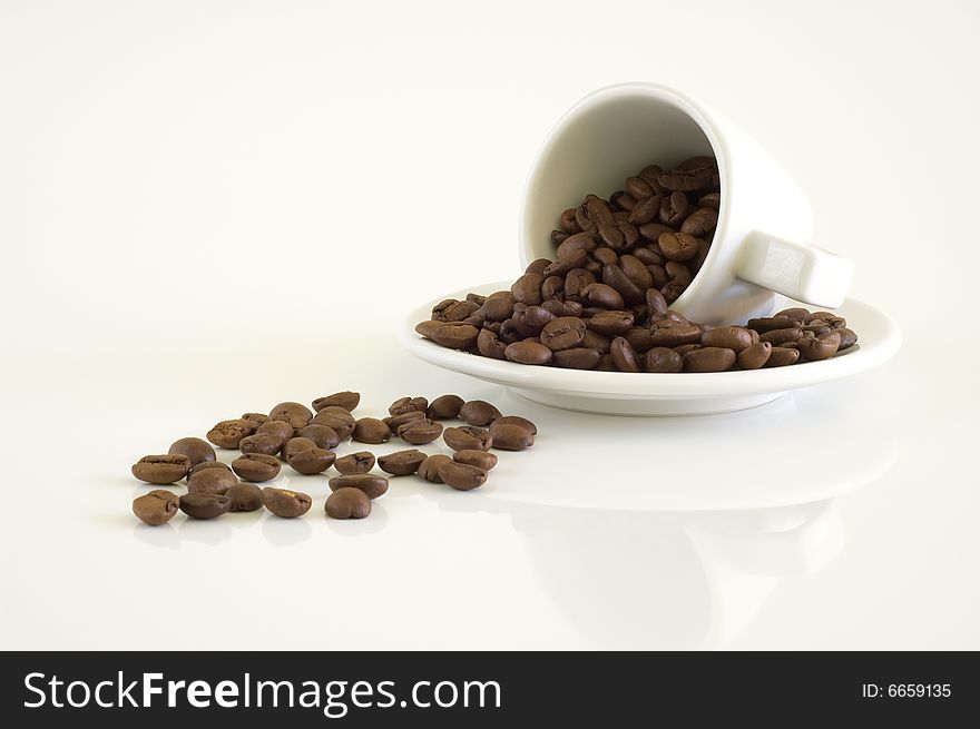 White coffee cup and coffee beans on a light background