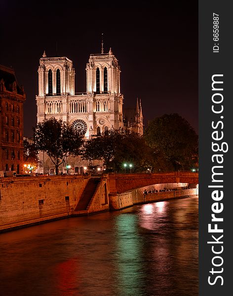 Notre Dame cathedral by night, in Paris, France, as seen from river Seine bank. Notre Dame cathedral by night, in Paris, France, as seen from river Seine bank