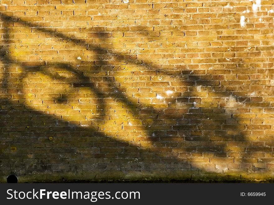 Shade of a bicycle on a red brick wall. Shade of a bicycle on a red brick wall