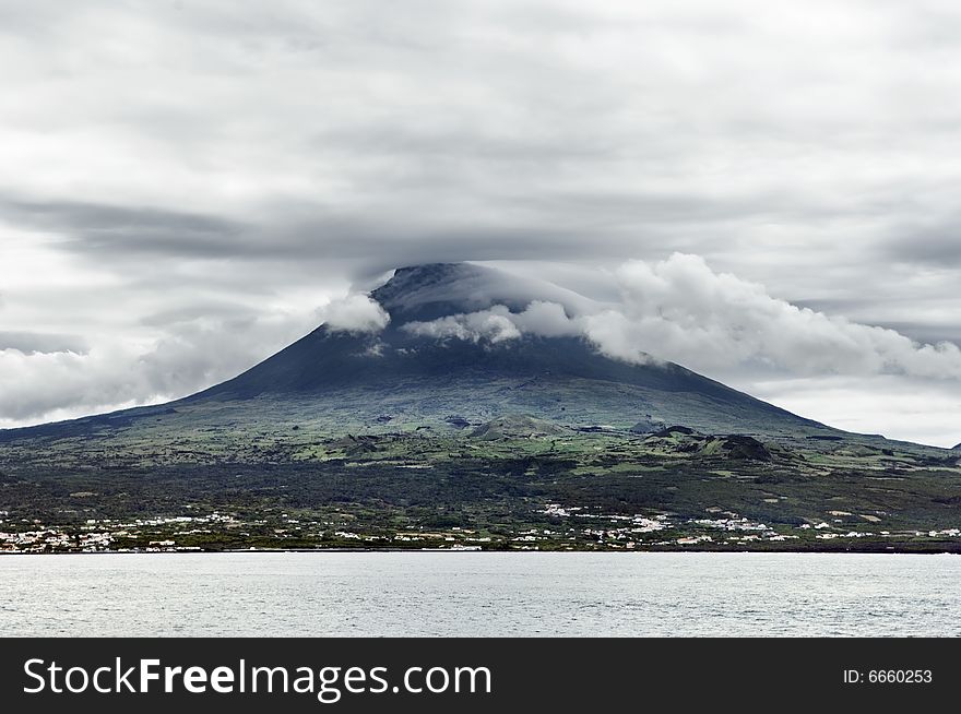 Overcast sky over Pico volcanic mountain view from the sea, Pico island, Azores, Portugal. Overcast sky over Pico volcanic mountain view from the sea, Pico island, Azores, Portugal
