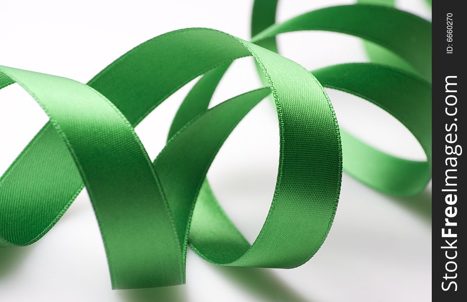 Green ribbon curling on white