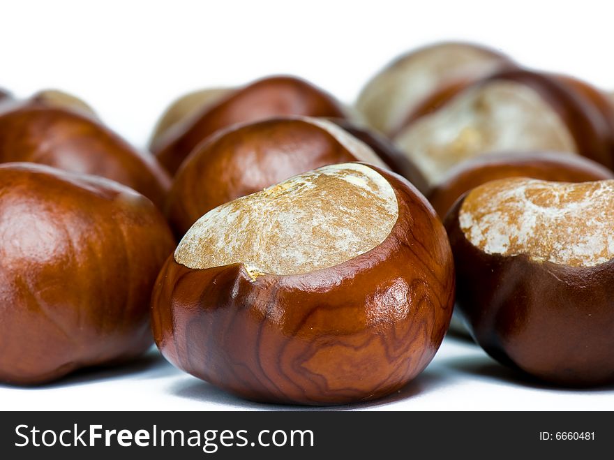 A few brown chestnuts are on a white background