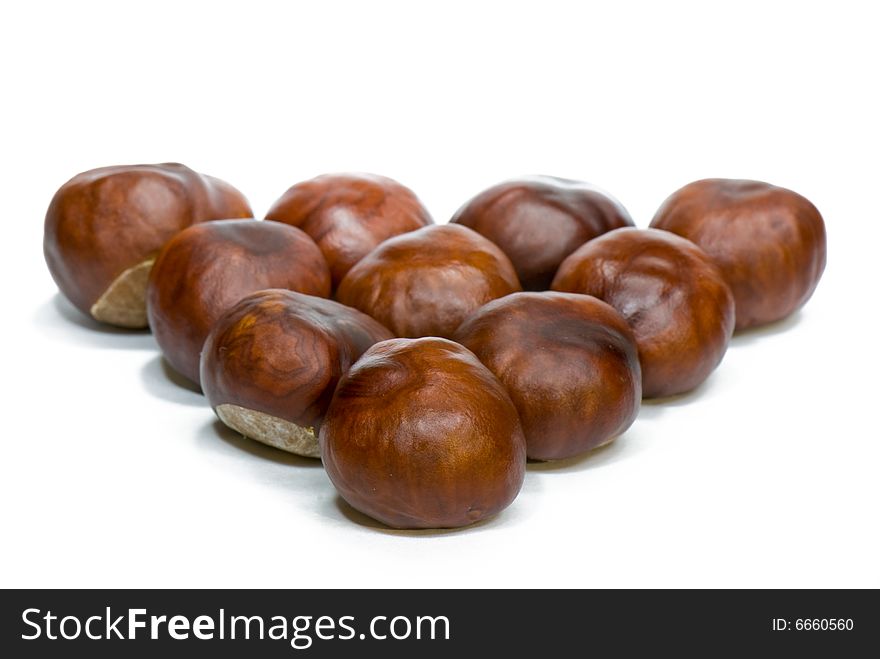 A few brown chestnuts are on a white background