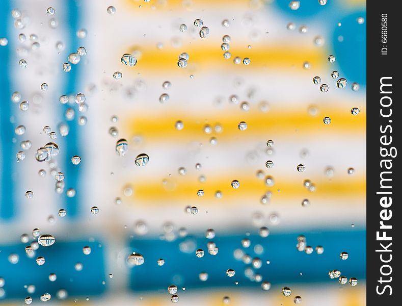 Flying drops of water on the bright coloured background