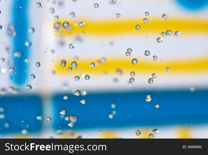 Flying drops of water on the bright coloured background